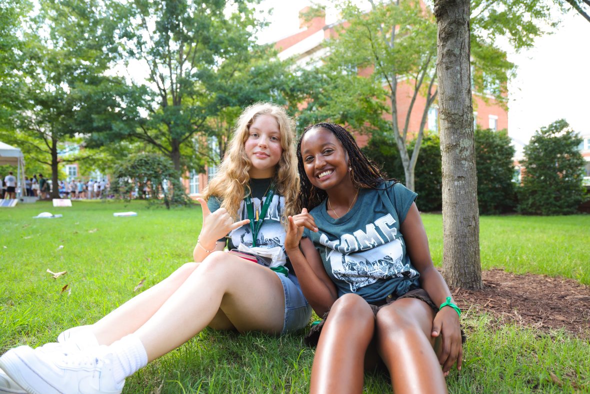 two students showing Niner pride outside